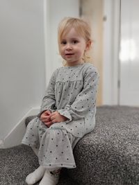 Portrait of cute girl sitting on floor at home
