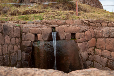 Water flowing through rocks against wall