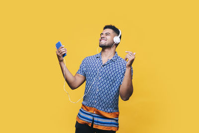 Full length of a young man against yellow background