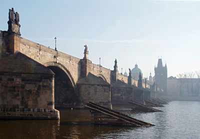 Bridge over river against buildings in city