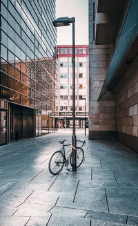 Bicycle parked on footpath by building