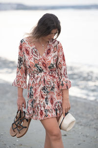 Midsection of woman standing at beach