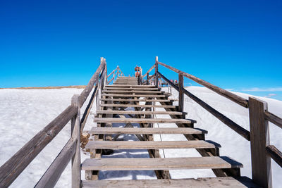 Low angle view of staircase against clear blue sky