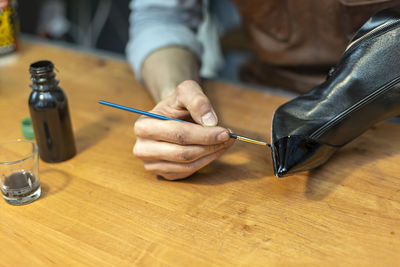 Close-up of hand holding pen on table