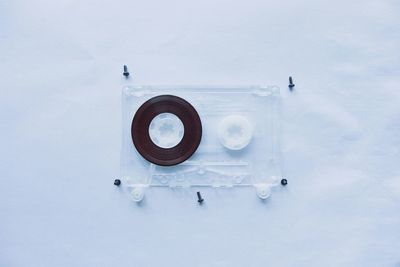 Directly above view of audio cassette with screws on white background