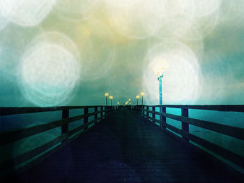 Footbridge over pier against sky