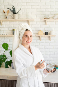 Portrait of a smiling young woman holding indoors