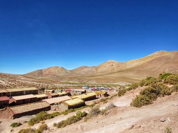 Scenic view of desert against clear blue sky