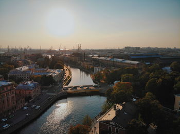 High angle view of river amidst buildings against sky during sunset