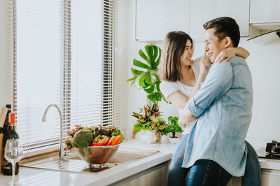 Playful couple romancing in kitchen