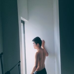 Rear view of shirtless man standing at home