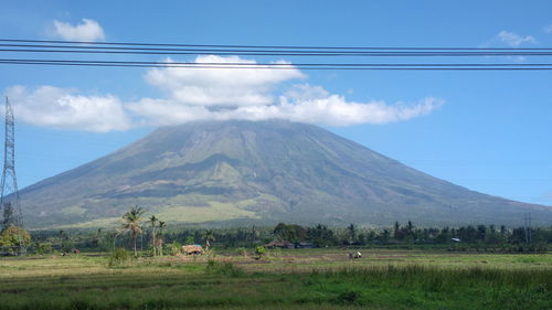 Scenic view of field and mountains against sky