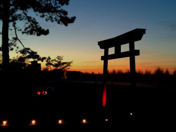 Silhouette built structure against sky at sunset