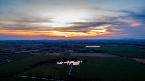 Scenic view of agricultural field against sky during sunset