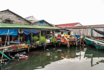 Boats in canal by building against clear sky