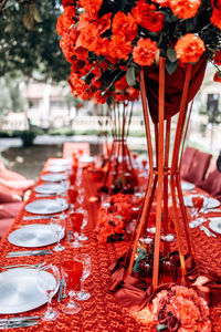 Red table wedding arrangement of roses, carnations on the background of a table with red tablecloth