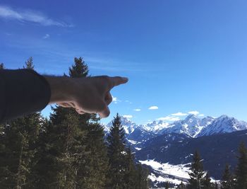 Man with snow on mountain against blue sky