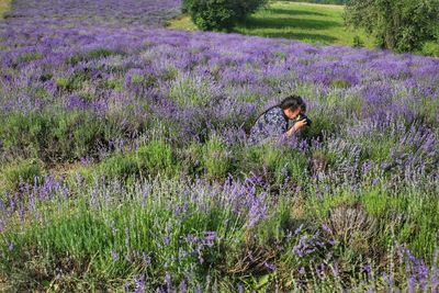 Side view of woman photographing on field