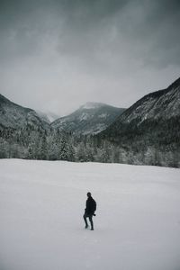 Man standing on snowcapped mountain against sky