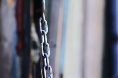 Close-up of chain hanging on metal fence