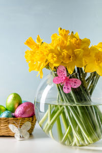 Close-up of yellow flowering plant in vase on table