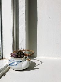 Potted plant on table against wall
