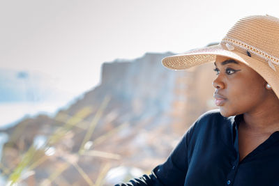 Portrait of beautiful african american model girl in stylish sun hat. fashion black woman on natural 