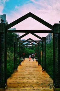 Rear view of people walking on footbridge