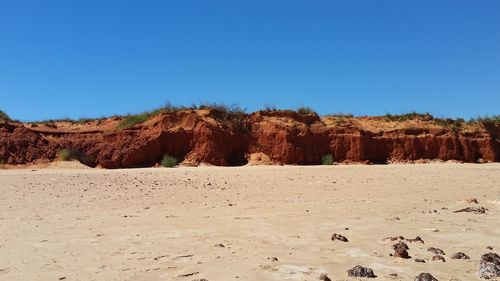 Scenic view of desert against clear blue sky