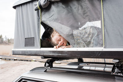 Portrait of boy looking through car