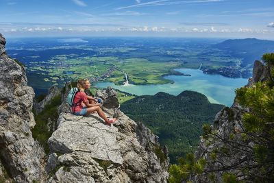 Germany, bavaria, young woman taking a break after running in the mountains