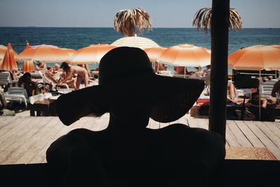 Rear view of people sitting on beach