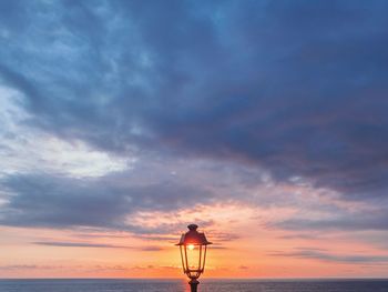 Silhouette man against orange sky