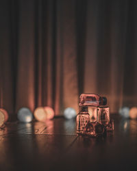 Candy bottles installation art with light balls grey curtains background at night 