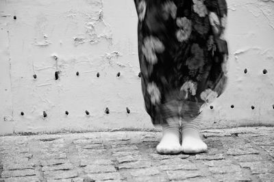 Low section of a woman standing against the wall