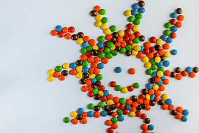 High angle view of multi colored candies against white background