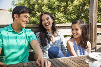 Happy family sitting at table on porch