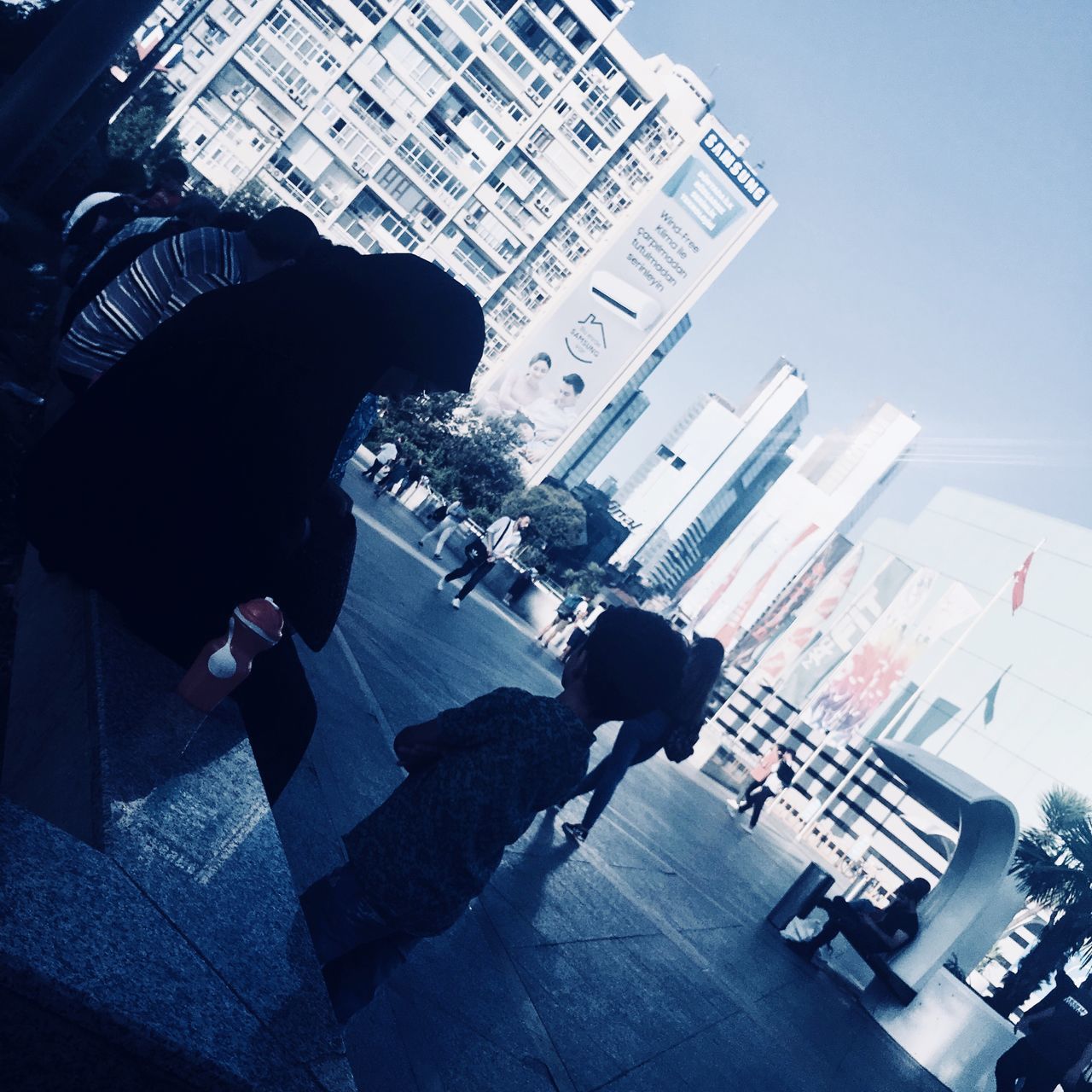 HIGH ANGLE VIEW OF PEOPLE WALKING IN CITY BUILDINGS