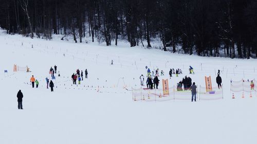 People on field against sky during winter