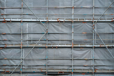 Building  under construction covered with scaffolds and grey mesh