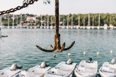 Close-up of rope tied to moored at shore against sky