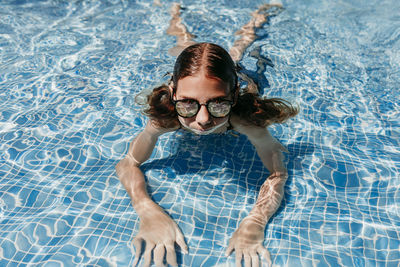 Portrait of a smiling young woman swimming in pool