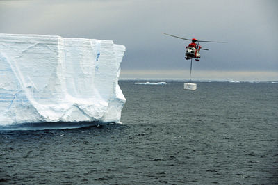 Helicopter carry freight over sea