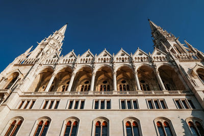 Low angle view of parliment building in budapest against clear blue sky