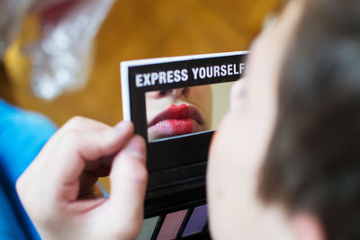 Close-up of woman holding hand mirror