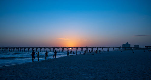 Pier over sea against sky during sunset