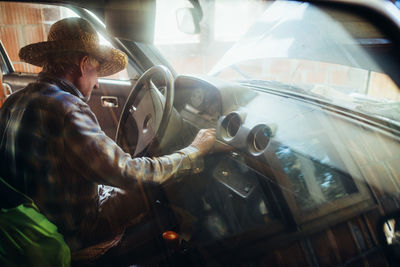 Side view of man working at bus