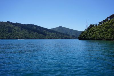 Scenic view of sea and mountains against clear sky