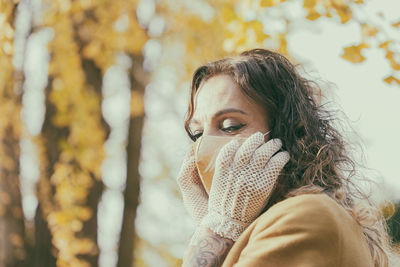 Portrait of woman in park during autumn
