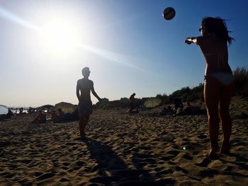 Silhouette of woman jumping at beach